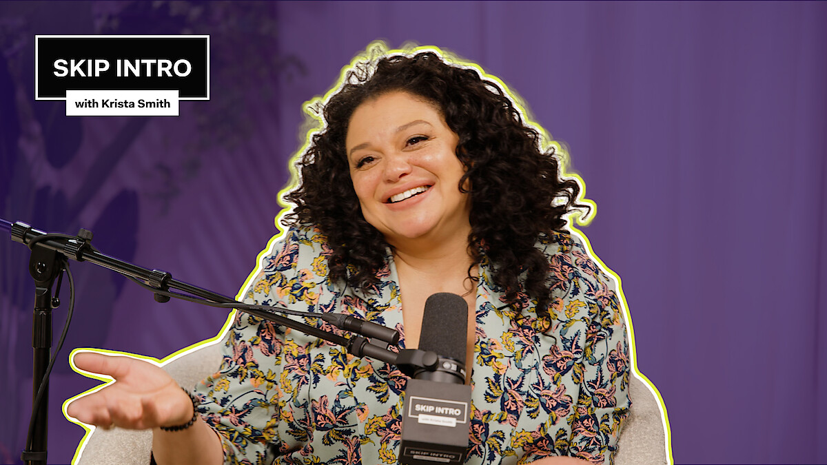 Michelle Buteau smiles and sits in front of a microphone, wearing a floral top. The background is purple, and there's a text box saying "SKIP INTRO with Krista Smith" in the top left corner.