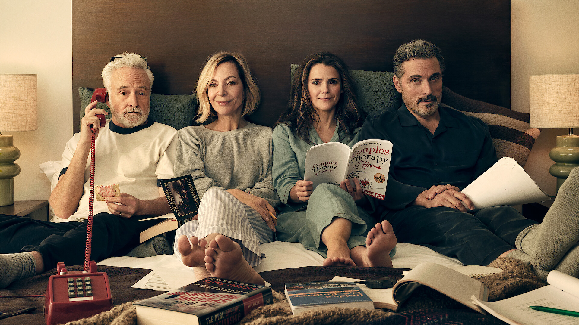 Keri Russell, Rufus Sewell, Allison Janney, and Bradley Whitford lounge in their pajamas together in bed.