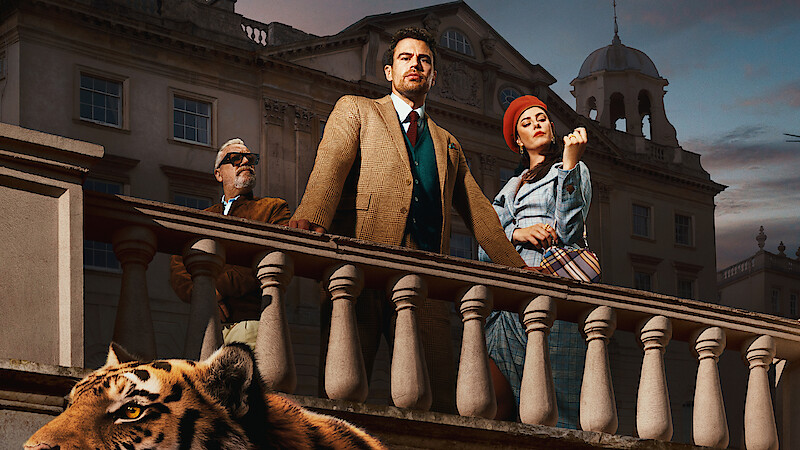 Three stylish people stand on a grand stone balcony in front of an elegant building at dusk, with a tiger at the bottom of the image, creating a dramatic and luxurious atmosphere.