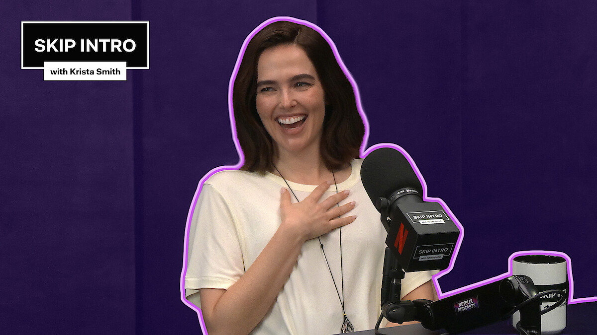 Zoey Deutch sits smiling and laughing in front of a microphone during a podcast recording for "Skip Intro with Krista Smith." The background is purple, and the podcast logo appears in the top left corner.