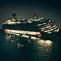 A large cruise ship listing heavily at night, brightly lit, with lifeboats and rescue craft on the water nearby, indicating an emergency situation at sea.