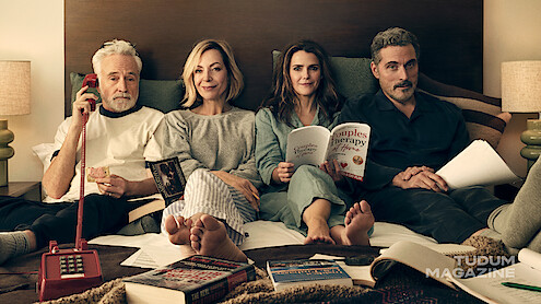 Keri Russell, Rufus Sewell, Allison Janney, and Bradley Whitford lounge in their pajamas together in bed.