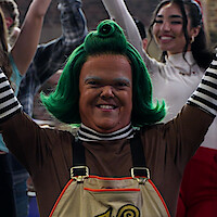 Contestant with Wonka's Golden Ticket next to an Oompa Loompa