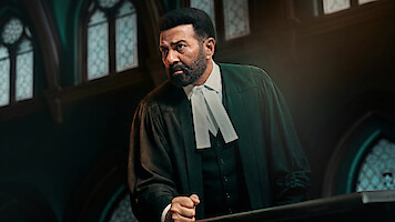 A serious lawyer in traditional black robes stands at a courtroom podium, making a passionate argument. Stained glass windows and gothic architecture create a dramatic, formal legal setting in the background.