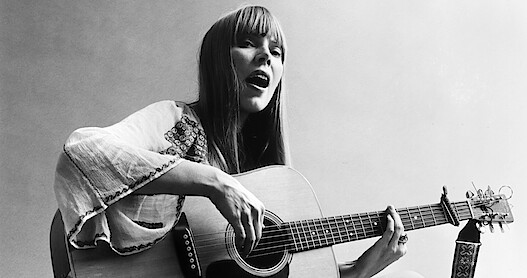 Black and white photo of Joni Mitchell playing the guitar