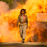 Iconic Scenes: Carlacia Grant in still from OBX show (woman walking in front of explosion)