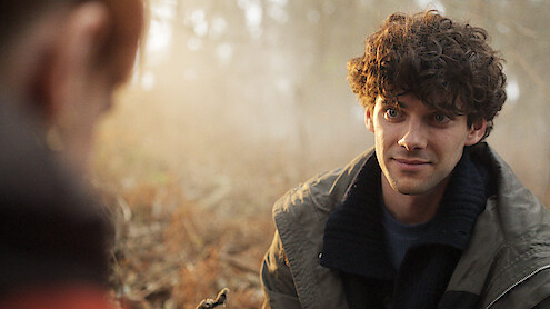  Álvaro Rico smiles while perched among a forest floor in an image from 'The Gardener.'
