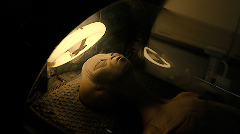 A Roswell alien lays on a table.