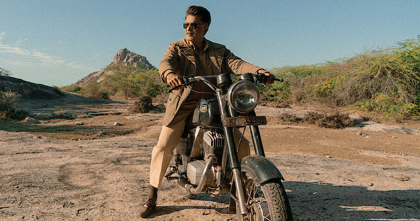 A main character sits astride a motorcycle