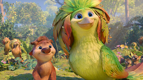 Animated scene with a smiling furry animal and a large colorful bird standing together in a vibrant, sunlit forest filled with foliage and other animal characters in the background.