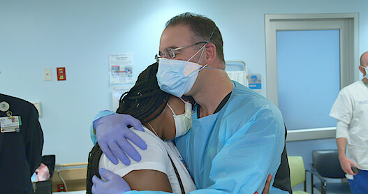 Doctor hugging/comforting an upset person (woman).