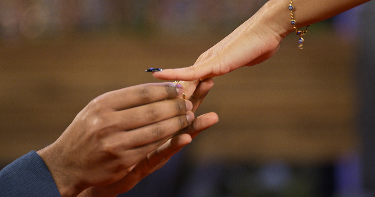 Person slides ring on finger. 