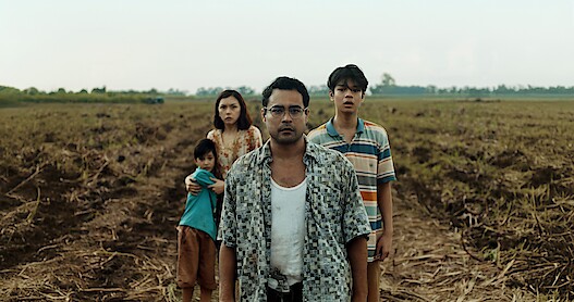 In an image from the film 'Outside,' standing in an empty field (from left to right), Aiden Tyler Patdu as Lucas, Beauty Gonzalez as Iris, Sid Lucero as Francis, and Marco Masa as Joshua. 