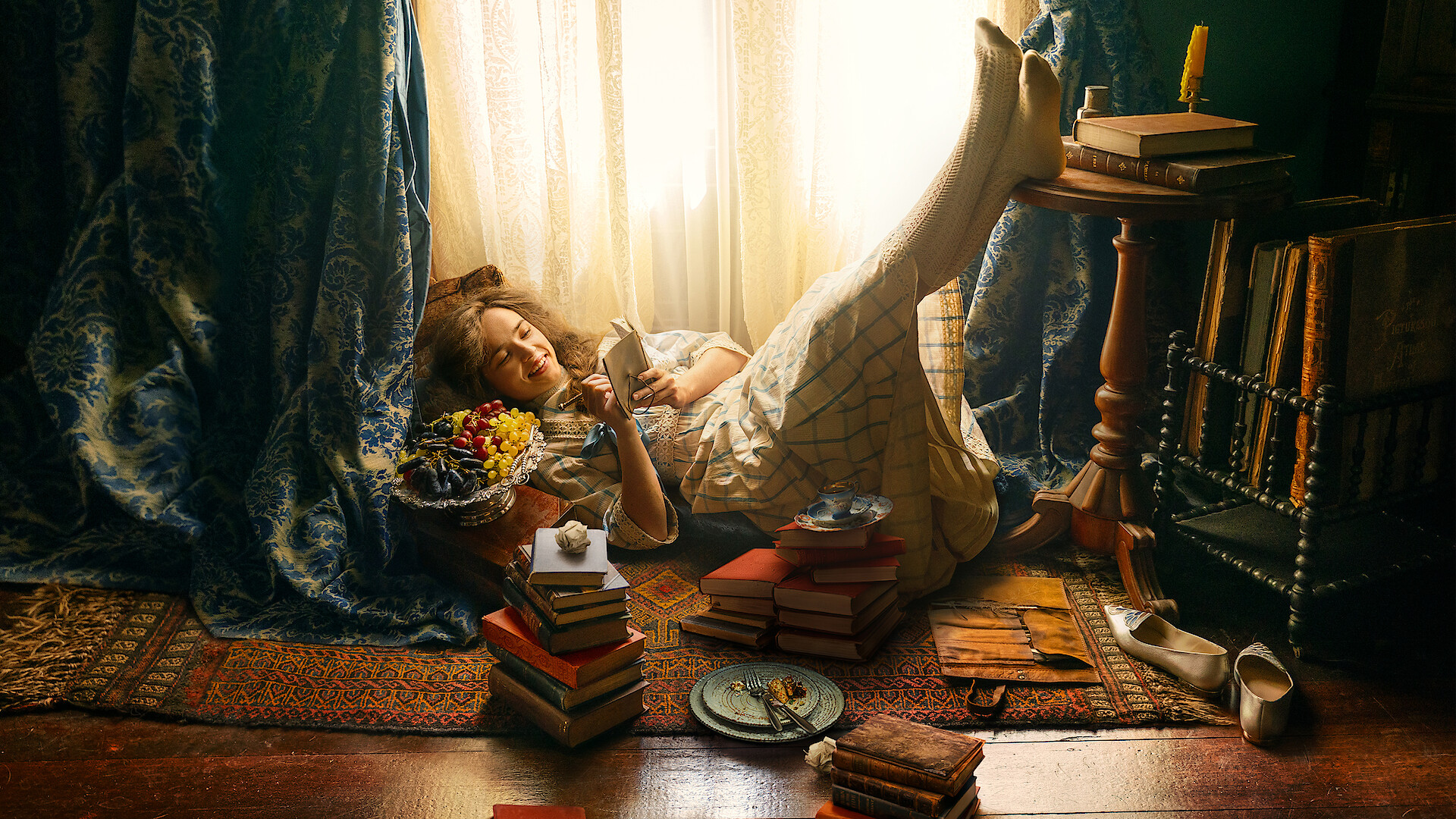 A woman in a vintage dress relaxes on the floor by a sunlit window, surrounded by stacks of books, flowers, and scattered personal items, in a cozy, softly lit, antique-style room with patterned curtains and a rug.