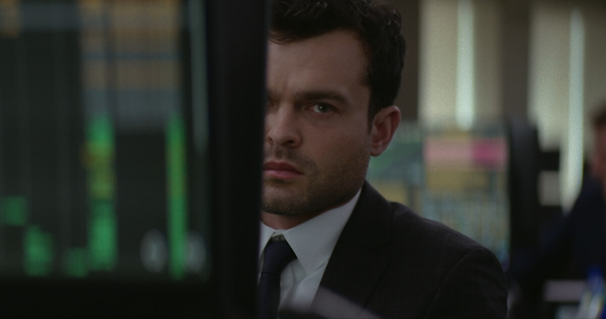 Alden Ehrenreich as Luke sitting in an office behind a computer.