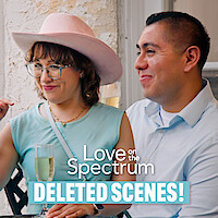 Two people sit together on a patio, one wearing a pink hat and holding a drink, both smiling. Text reads "Love on the Spectrum Deleted Scenes!" The environment looks relaxed and friendly.