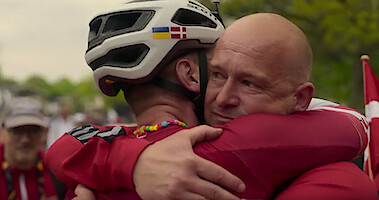 Man hugging another man wearing a bicycle helmet