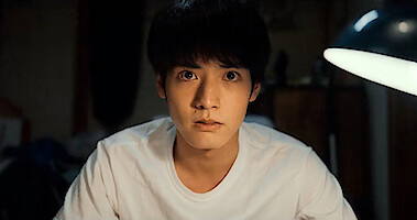 Man in a white t-shirt staring at the camera