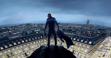 Omar Sy as Assane Diop stands on a tower above the streets of Paris in Season 3 of 'Lupin.'