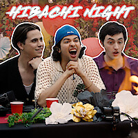 From left to right, Tanner Buchanan, Xolo Maridueña, and Gianni DeCenzo are seated at a dinner table, with a flame rising dramatically on the right side.
