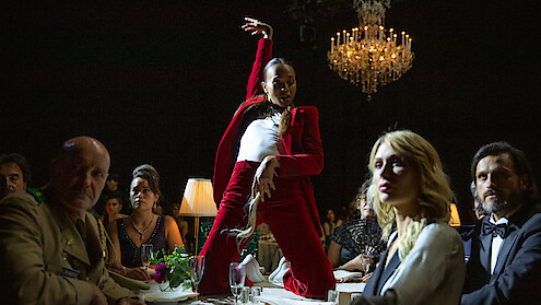 Zoe Saldaña strikes a pose on top of a table while performing the standout song from the film, "El Mal."