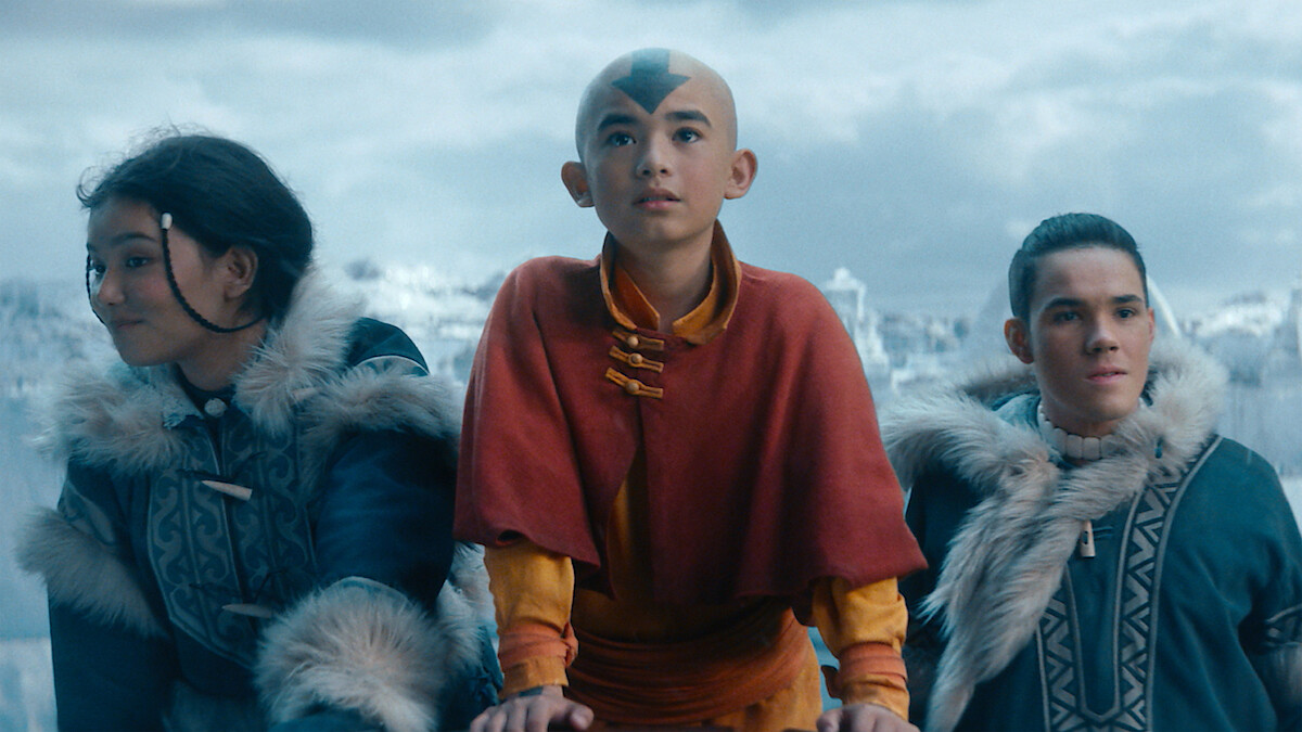 Three young children stand together in an arctic setting.