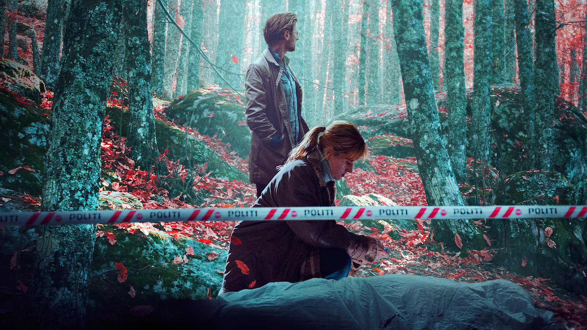 Two detectives at a crime scene in a misty forest, with one kneeling beside a covered body on the ground and police tape marked "politi" in the foreground. The forest floor is covered with red leaves.