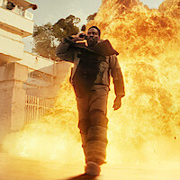 A man standing in front of an explosion of fire