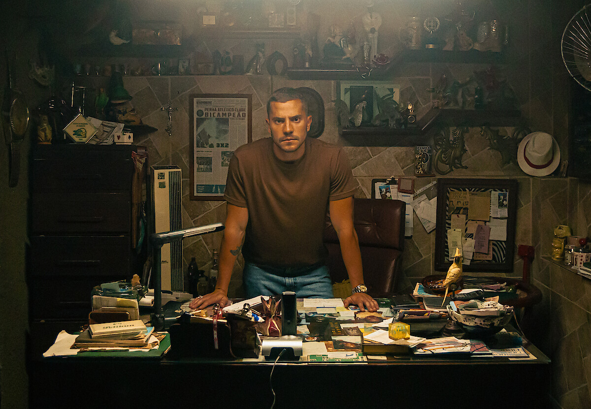 André Lamoglia posa em um escritório do jogo do bicho, em cena da série "Os Donos do Jogo"