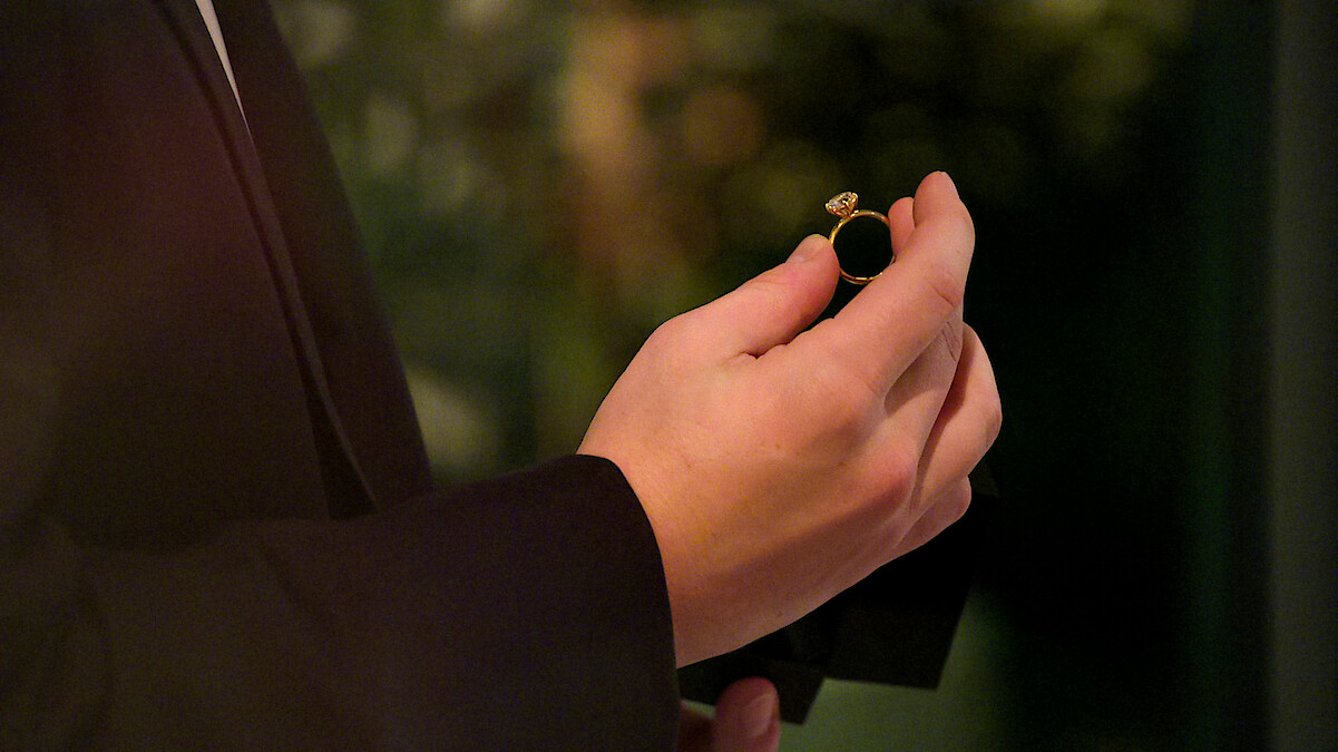 A man holding an engagement ring.