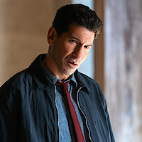 Jon Bernthal wearing a blue shirt and red tie in His & Hers
