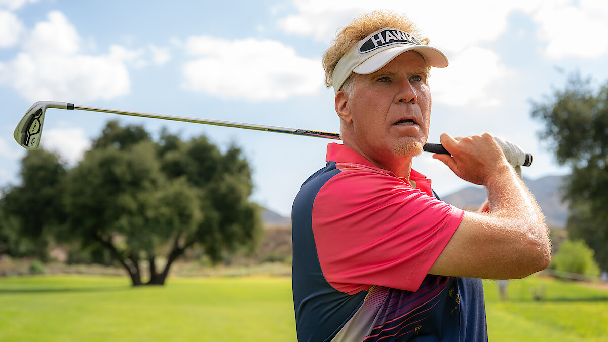 Man holding a golf club on a sunny golf course, wearing a visor and polo shirt, with green grass, trees, and a blue sky with clouds in the background.