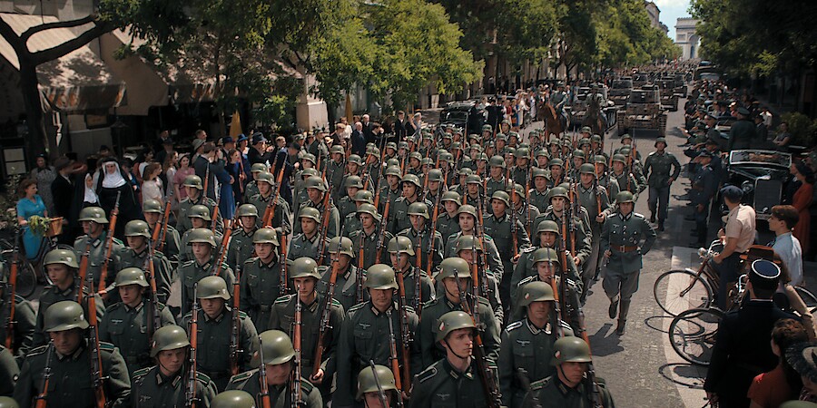 A street filled with columns of soldiers marching. 