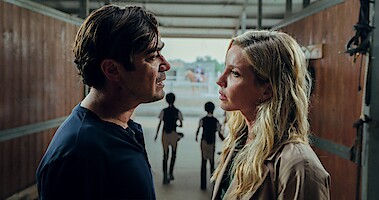 Riccardo Scamarcio as Pietro La Torre and Annabelle Wallis as Elena Walgren stand and face each other with concerned expressions in 'Vanished into the Night'