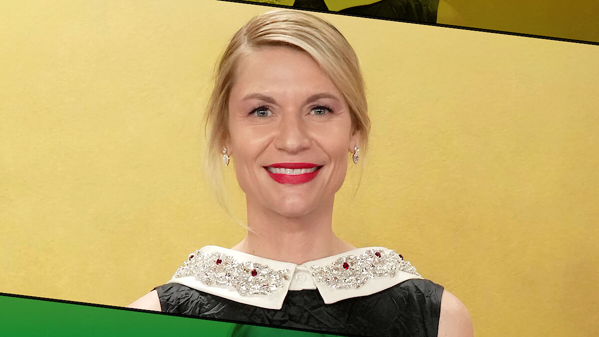 Woman with blonde hair and red lipstick smiling, wearing a black dress with a jeweled white collar, standing in front of a yellow background with green and black graphic accents.