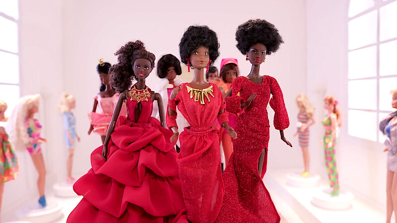 Black Barbie dolls posed together.
