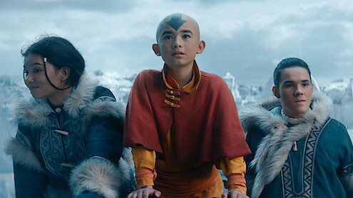 Three young children stand together in an arctic setting.