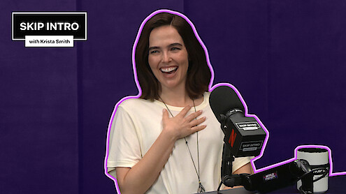 Zoey Deutch sits smiling and laughing in front of a microphone during a podcast recording for "Skip Intro with Krista Smith." The background is purple, and the podcast logo appears in the top left corner.