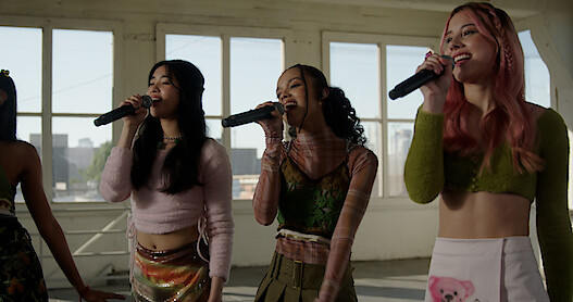 Sophia, Samara, and Celeste sing into microphones.