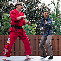 William Zabka as Johnny Lawrence, Ralph Macchio as Daniel LaRusso, and Yuji Okumoto as Chozen in stand in fighting positions in Season 6 of 'Cobra Kai.'