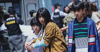Ahn Eun-jin wears a blue sling while embracing a child in an image from the sci-fi series 'Goodbye Earth.'