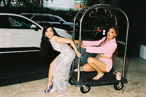 Ramona Young and Lee Rodriguez on a luggage cart