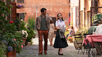 Lily Collins as Emily and Lucas Bravo as Gabriel stand on a bridge over the Seine in Season 4 of 'Emily in Paris'