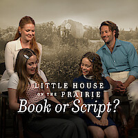 The Ingalls family sitting and smiling with a prairie backdrop, reading and looking at a book. 