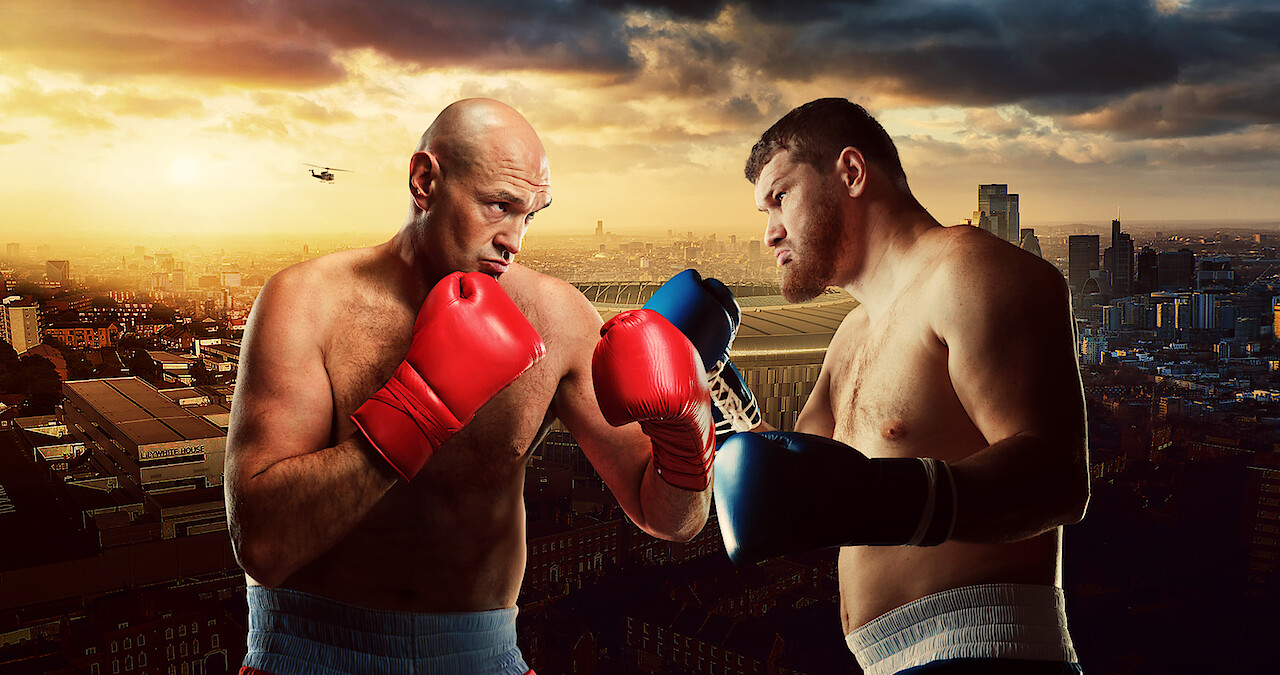 Two male boxers with gloves face off in a dramatic pose against a city skyline at sunset, creating a tense and competitive atmosphere.