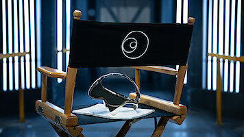 A director's chair with the '3 Body Problem' logo and a headset resting on it.