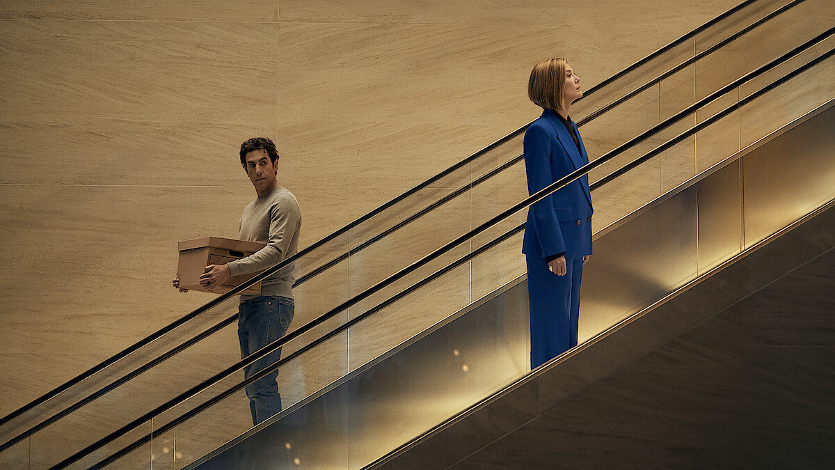 Ladies First. (L-R) Sacha Baron Cohen as Damien Sachs and Rosamund Pike as Alex Fox in Ladies First. Cr. Rob Youngson/Netflix © 2026.