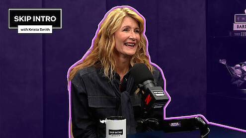 Laura Dern sits smiling in front of a microphone during a podcast recording for "Skip Intro with Krista Smith." The background is purple, and the podcast logo appears in the top left corner.