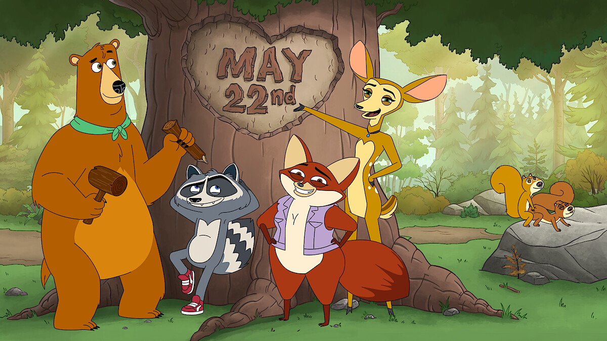 Four cartoon animals—a bear, raccoon, fox, and deer—stand by a large tree in a forest with "May 22nd" carved in its trunk. Two squirrels are on a rock in the background. The setting is bright and cheerful.