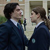 Simone Baldasseroni as Riguel and Caterina Ferioli as Nica face each other wearing private school uniforms in 'The Tearsmith'